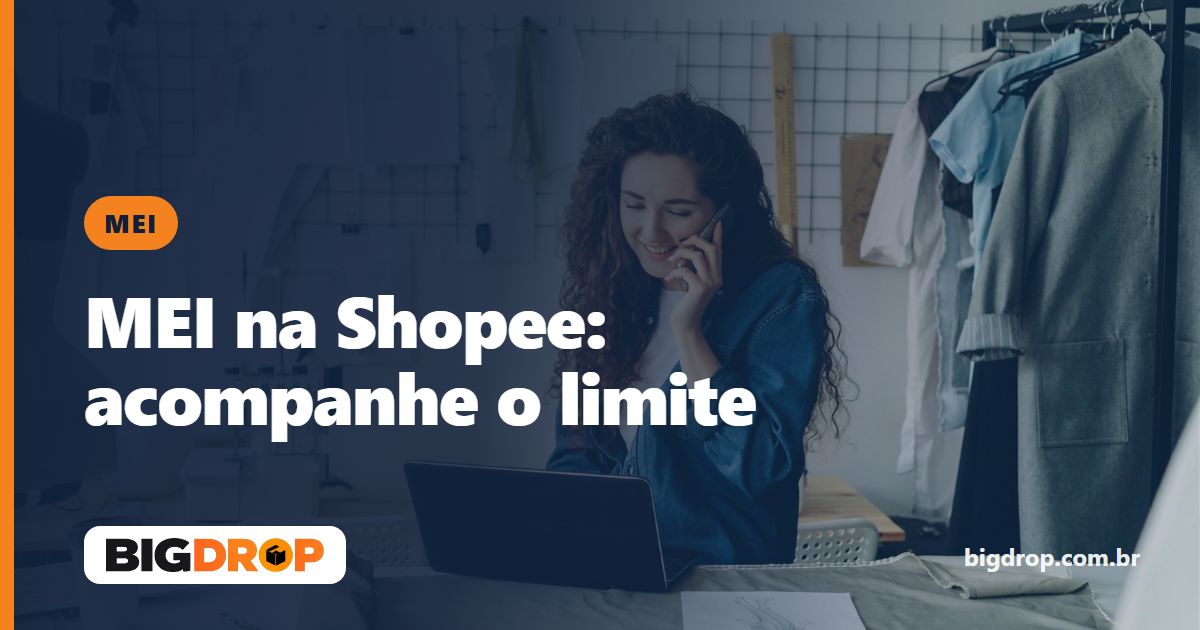 Empreendedora ao telefone diante do notebook em um ateliê de costura